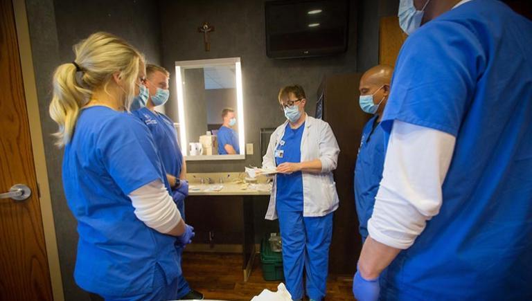 Nursing students gathered around a faculty member