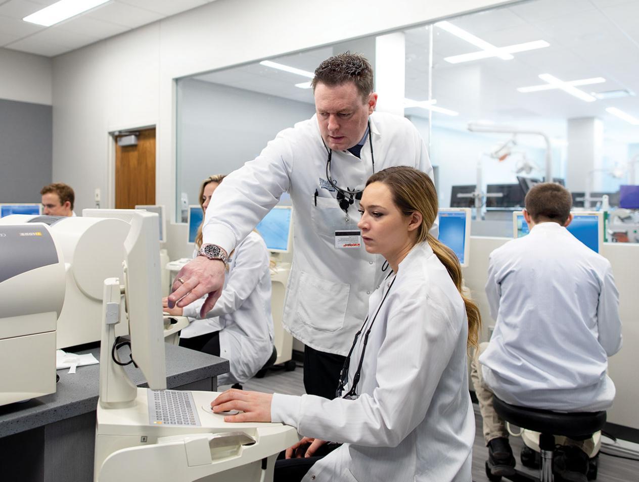 Dental student and professor on computer