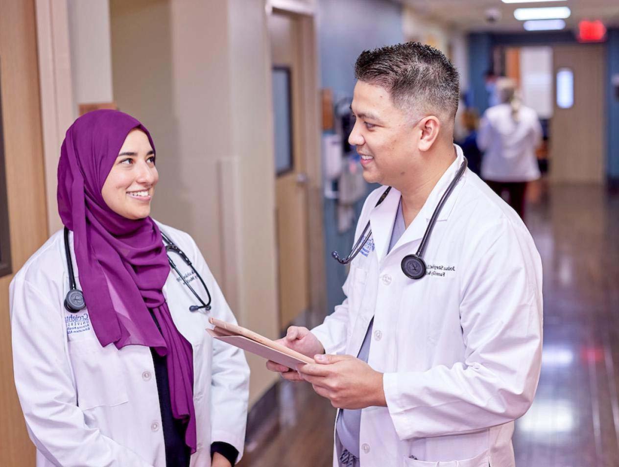 Residents conversing in hospital hallway.