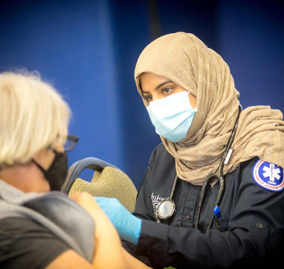 EMS student administering vaccine