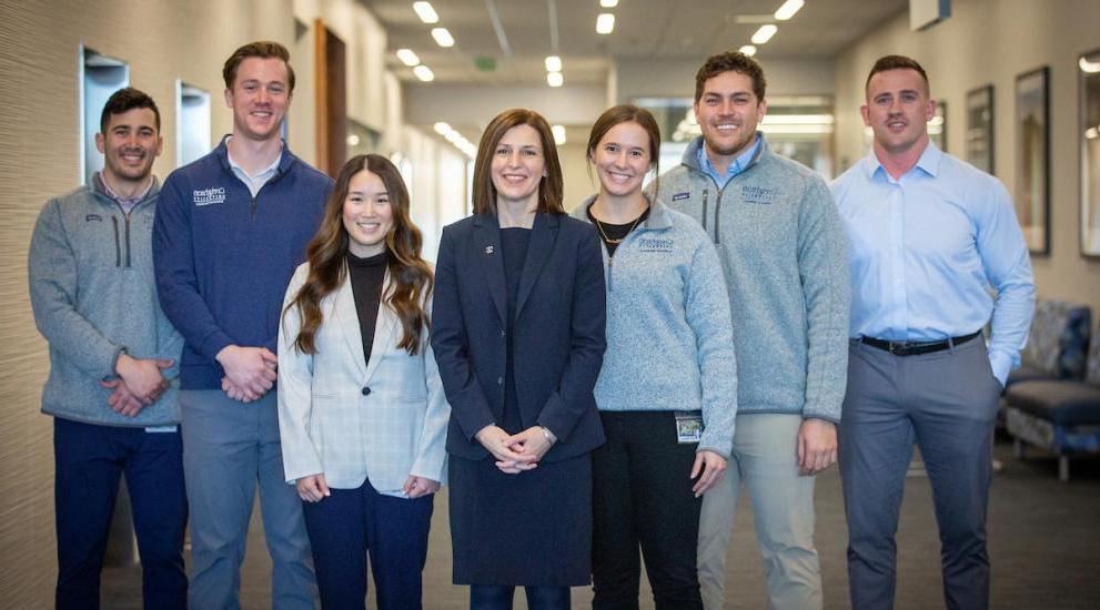 Dean Wallen with dental students posing for photo smiling.